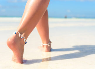 femme avec bracelet de cheville marchant sur une plage