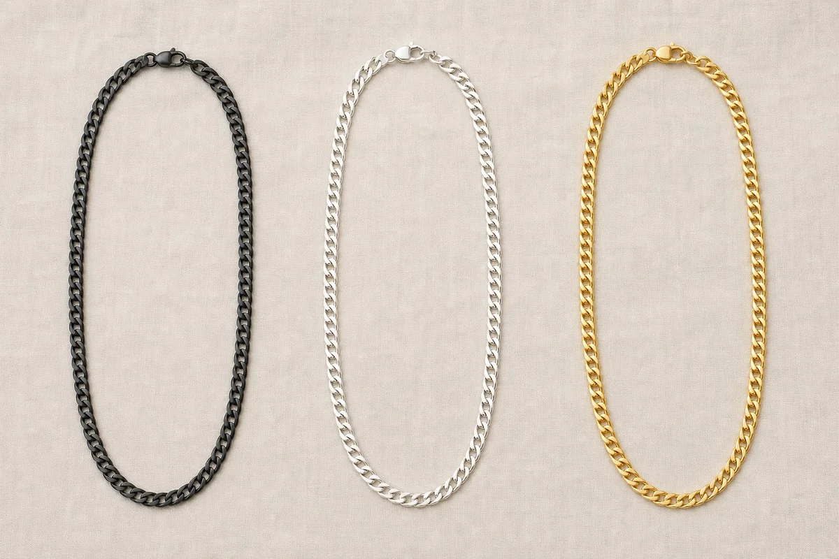 Matériaux collier homme : acier inoxydable, argent 925, or jaune Trois colliers homme posés côte à côte : acier inoxydable noir, argent 925, et or jaune 18 carats